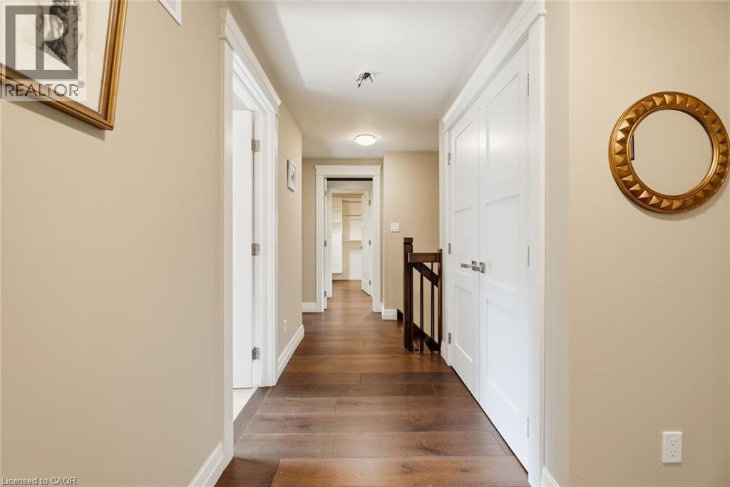 Hallway featuring wood-finish flooring, light tan wall color, white trim, and white paneled doors - 266 Ferndale Place, Waterloo, ON - Indoor Photo Showing Other Room