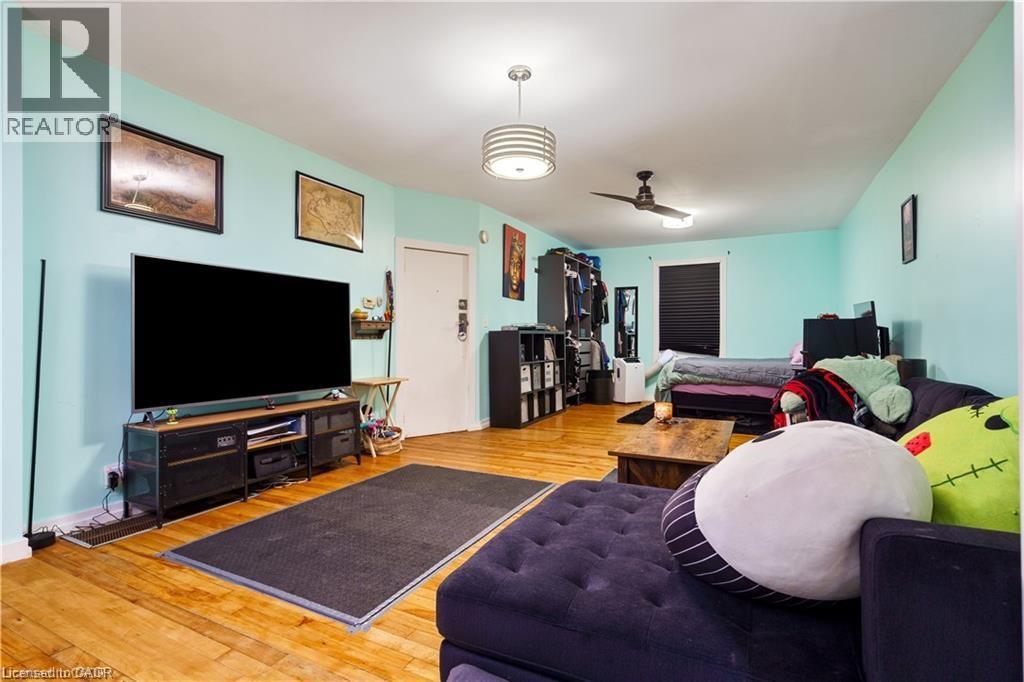 Spacious room featuring hardwood flooring, light blue walls, and a ceiling fan - 219 Avondale Street, Hamilton, ON - Indoor Photo Showing Living Room