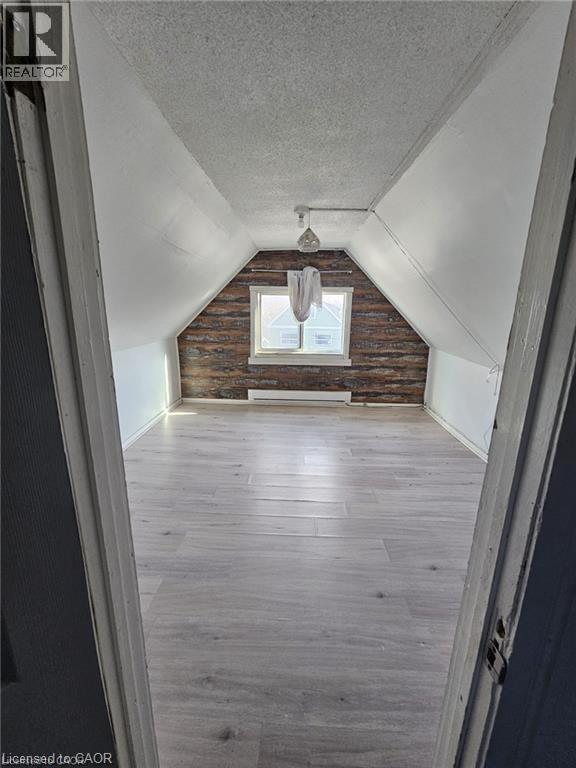 Versatile room featuring light-toned flooring, a window, and exposed wood paneling on one wall - 219 Avondale Street, Hamilton, ON - Indoor Photo Showing Other Room