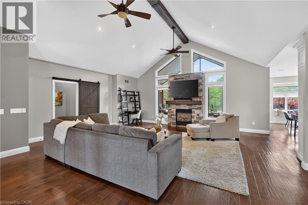 Vaulted ceiling with exposed beam and twin ceiling fans - 2050 15 Side Road, Milton, ON - Indoor Photo Showing Living Room With Fireplace