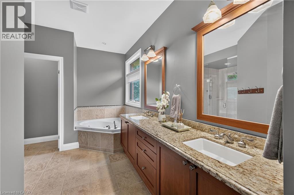 Bathroom featuring a dual vanity with a patterned countertop, wood cabinetry, and undermount sinks - 2050 15 Side Road, Milton, ON - Indoor Photo Showing Bathroom