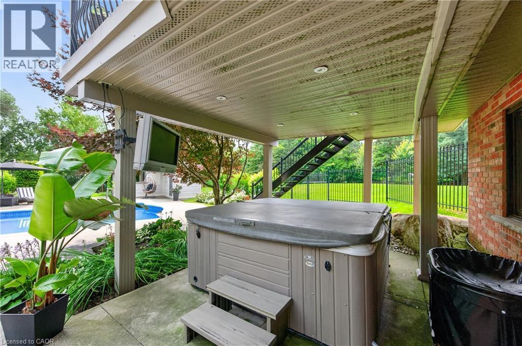Covered patio featuring a hot tub with integrated steps, mounted television, and recessed lighting - 2050 15 Side Road, Milton, ON - Outdoor With Deck Patio Veranda With Exterior