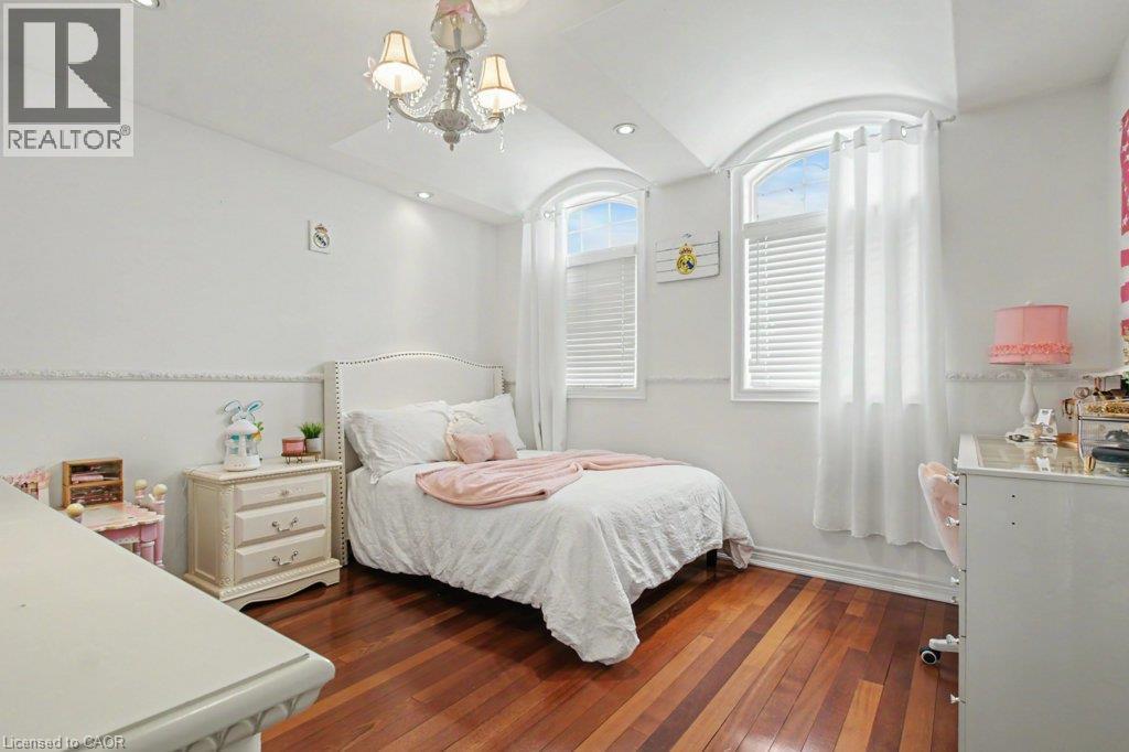 Room featuring rich wood-finish flooring, white walls, and a decorative baseboard - 284 Normanhurst Avenue, Hamilton, ON - Indoor Photo Showing Bedroom