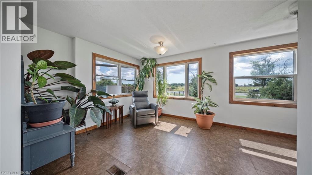 Sunlit room featuring multiple windows with natural wood trim, light-toned walls, and wood-finish flooring - 3211 Highway 3, Jarvis, ON - Indoor