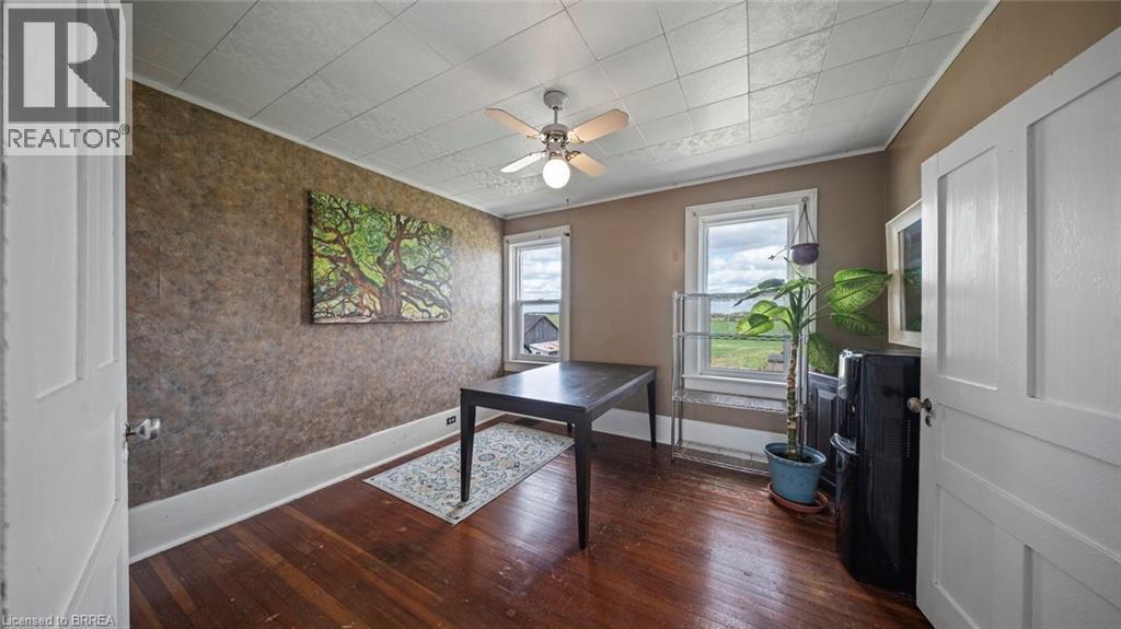 Room featuring wood-finish flooring, two windows with trim, and a ceiling fan with integrated lighting - 3211 Highway 3, Jarvis, ON - Indoor Photo Showing Other Room