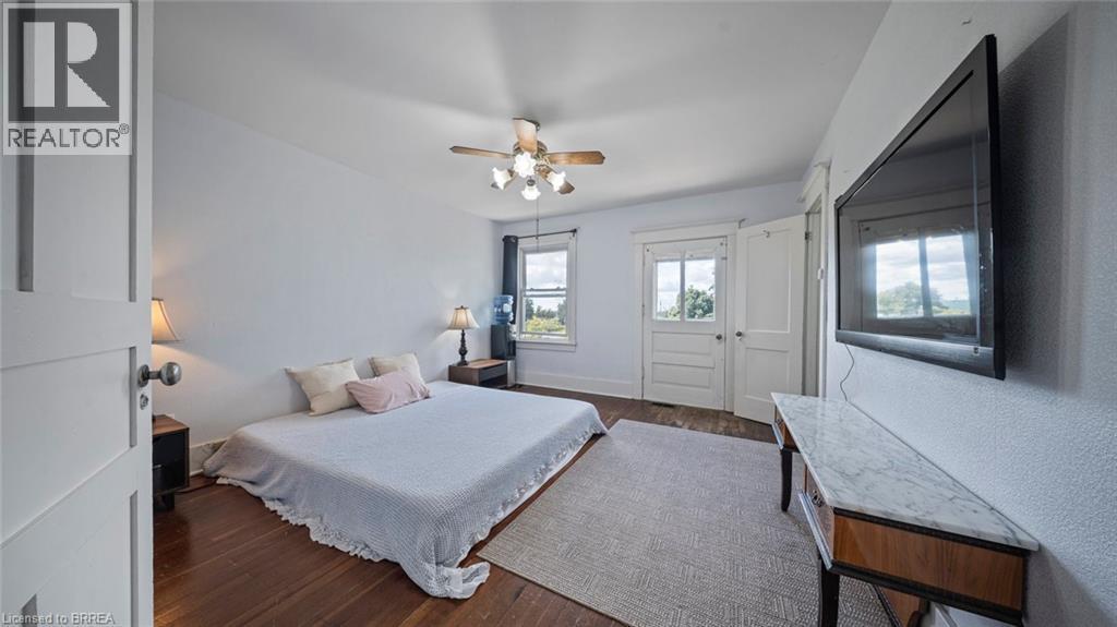Bedroom featuring wood-finish flooring, a ceiling fan with light fixture, and white painted walls - 3211 Highway 3, Jarvis, ON - Indoor Photo Showing Bedroom