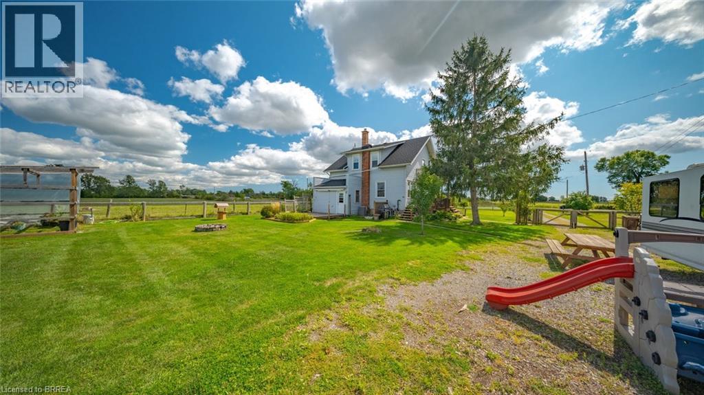 Expansive rear yard featuring a manicured lawn, established trees, and perimeter fencing - 3211 Highway 3, Jarvis, ON - Outdoor