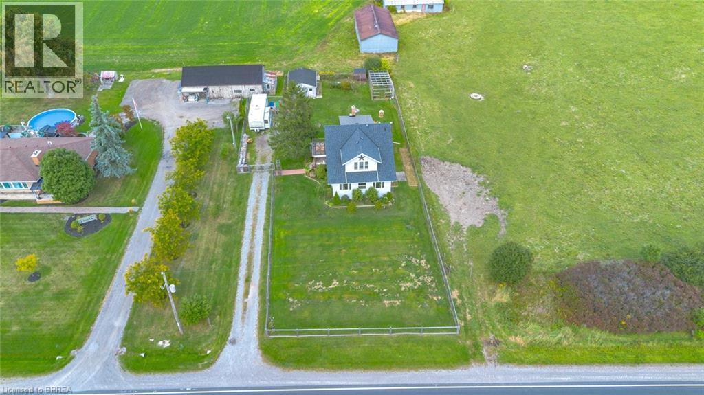 Property featuring a white two-story residence with a dark roof, surrounded by expansive green lawns - 3211 Highway 3, Jarvis, ON - Outdoor With View