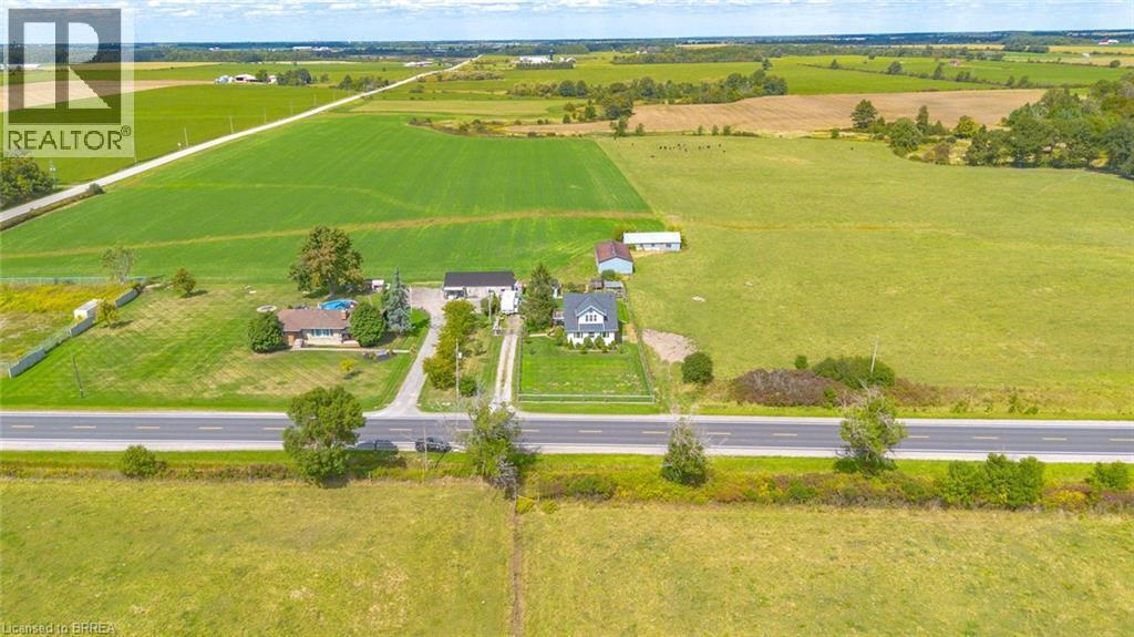 Expansive rural property featuring multiple residential structures, a detached garage, and a swimming pool - 3211 Highway 3, Jarvis, ON - Outdoor With View