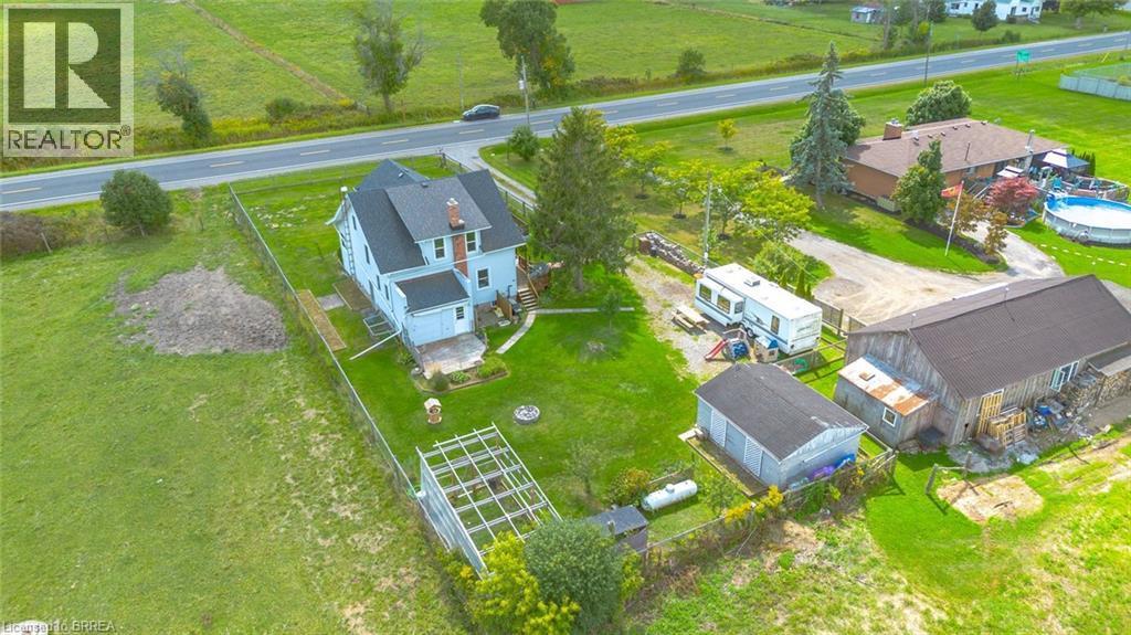 Expansive property with a light-colored two-story residence, featuring a dark-shingled roof and prominent chimney - 3211 Highway 3, Jarvis, ON - Outdoor With View