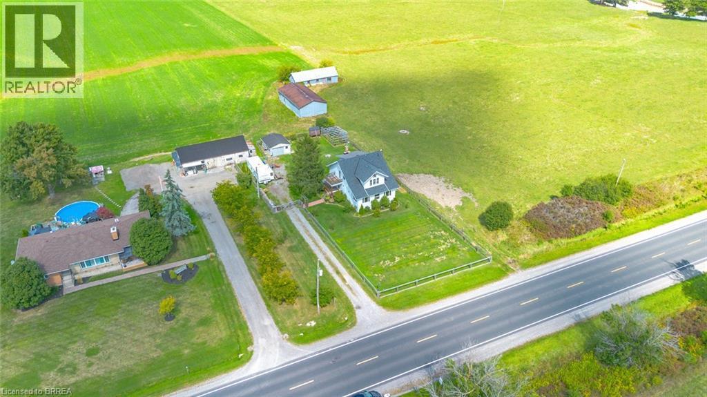 Expansive property featuring a white residence with a dark roof, surrounded by green fields - 3211 Highway 3, Jarvis, ON - Outdoor With View