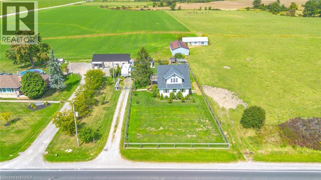 White residential structure featuring a dark roof, multiple gables, and a front porch - 3211 Highway 3, Jarvis, ON - Outdoor With View