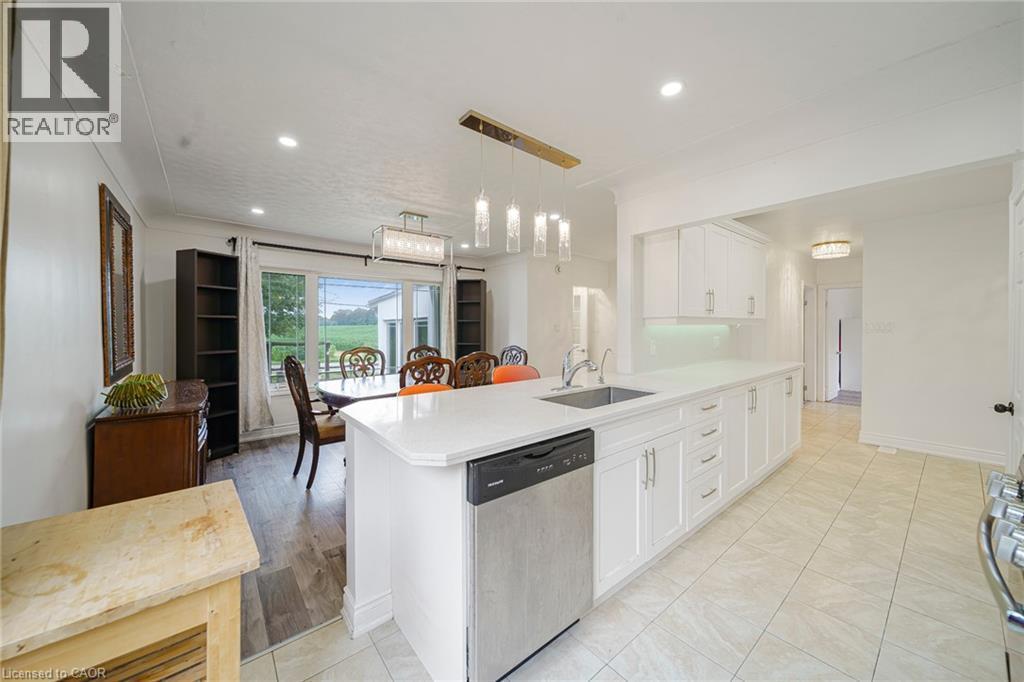 Kitchen featuring white cabinetry, light-toned tiled flooring, and a stainless steel dishwasher - 7332 Twenty Road E, Glanbrook, ON - Indoor Photo Showing Kitchen