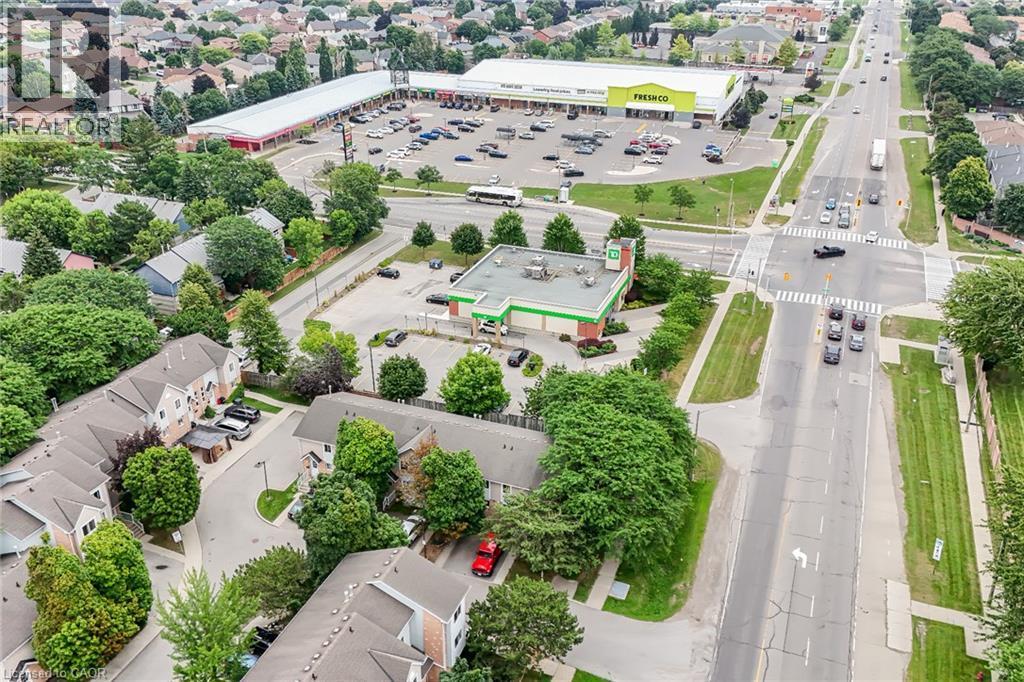 Aerial perspective showcasing a retail plaza featuring a grocery store and additional commercial spaces - 7332 Twenty Road E, Glanbrook, ON - Outdoor With View
