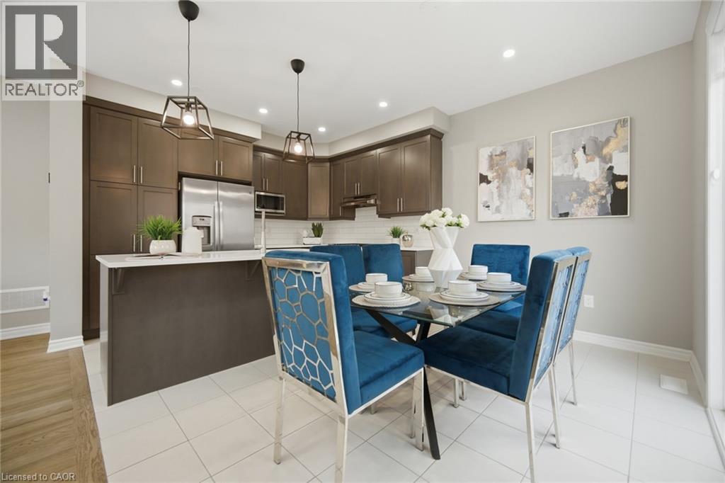 Contemporary kitchen and dining area featuring dark wood-finish cabinetry, stainless steel appliances, a white subway tile backsplash, and light-colored tile flooring - 542 Boyd Lane, Milton, ON - Indoor Photo Showing Dining Room