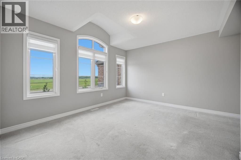 Bright interior featuring a vaulted ceiling and light gray carpeting - 542 Boyd Lane, Milton, ON - Indoor Photo Showing Other Room