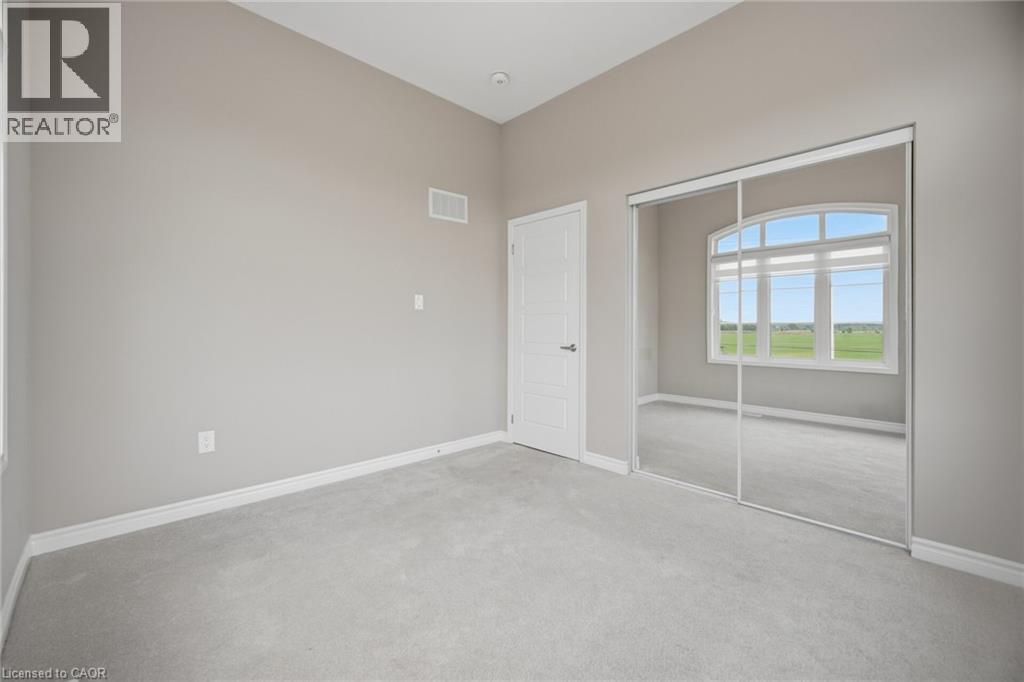 Spacious room featuring neutral carpeting, light gray wall paint, and white baseboards - 542 Boyd Lane, Milton, ON - Indoor Photo Showing Other Room