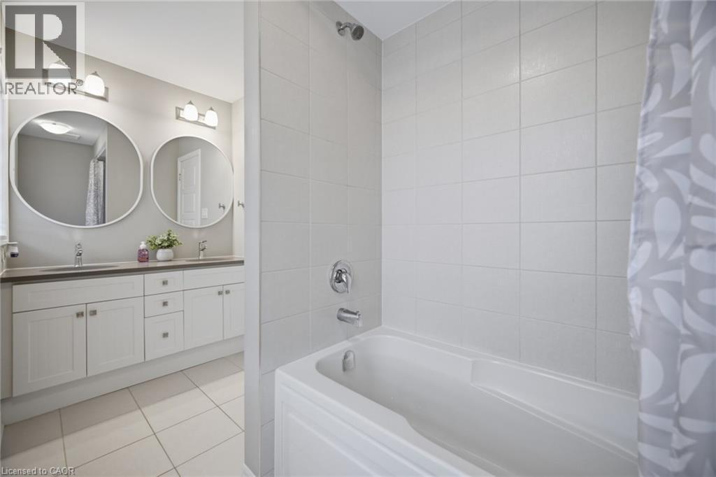Bathroom featuring a white tiled bath and shower combination with chrome fixtures - 542 Boyd Lane, Milton, ON - Indoor Photo Showing Bathroom