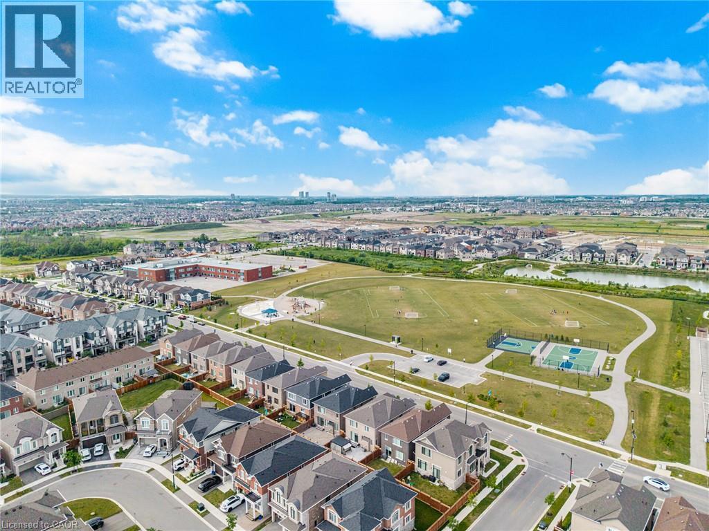 Extensive green space featuring a sports court, playground, and paved walking paths - 542 Boyd Lane, Milton, ON - Outdoor With View
