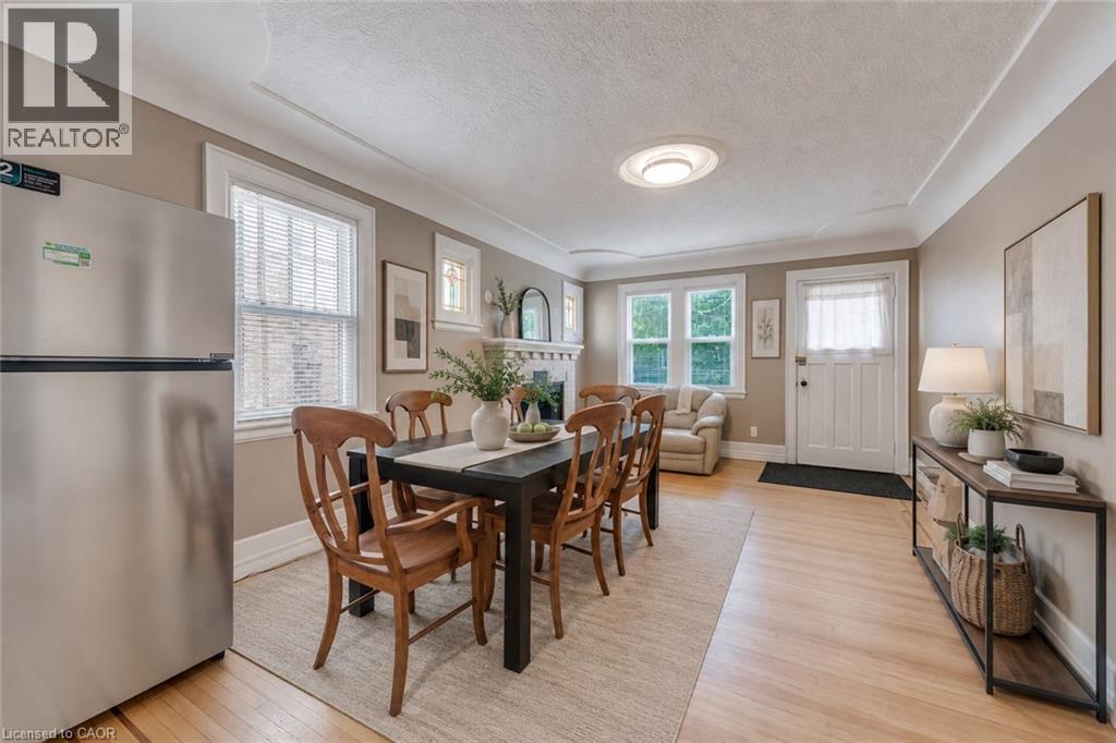 Warm-toned wood-finish flooring complements the neutral wall color - 74 Royal Avenue, Hamilton, ON - Indoor Photo Showing Dining Room