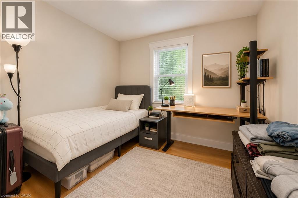 Light-filled room featuring wood-finish flooring, a window with blinds, and neutral wall tones - 74 Royal Avenue, Hamilton, ON - Indoor Photo Showing Bedroom