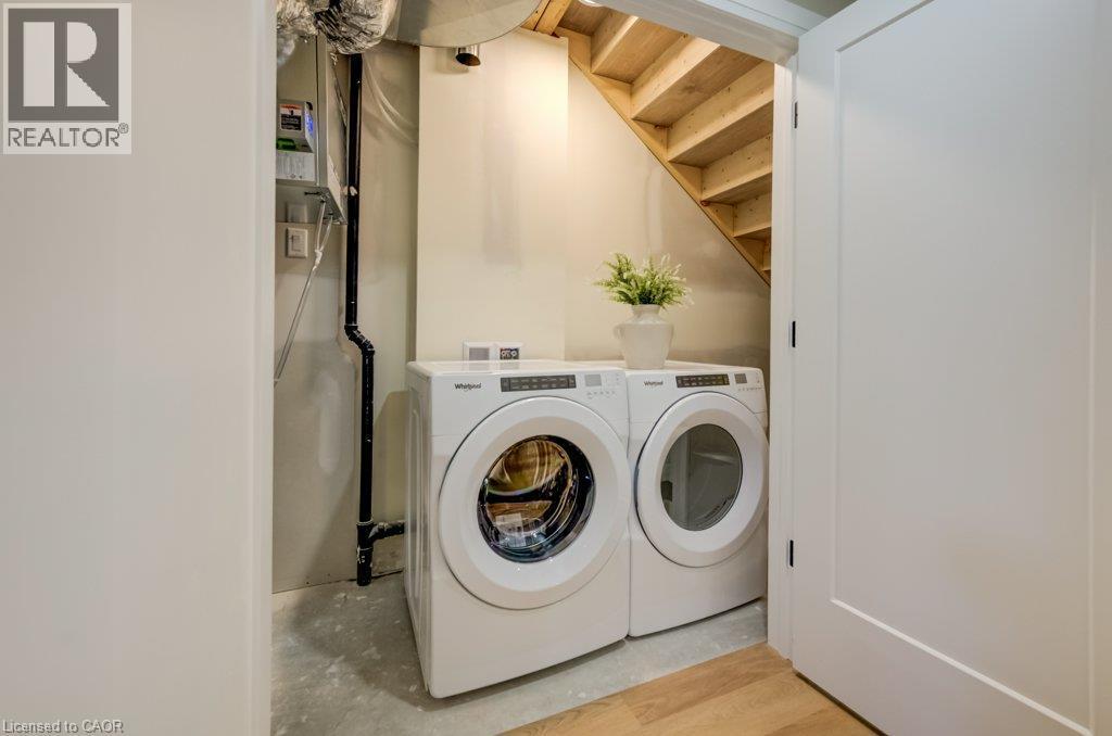 Dedicated laundry area with concrete flooring, under-stair storage, and a white interior door - 210 Heritage Drive Unit# Main, Kitchener, ON - Indoor Photo Showing Laundry Room