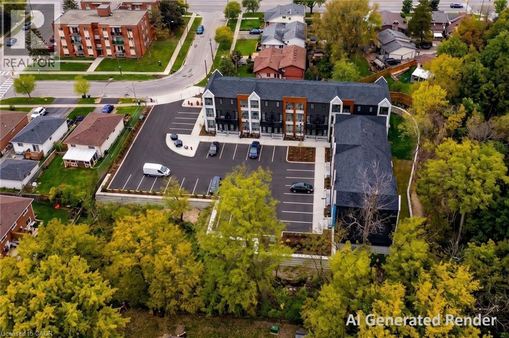 Modern multi-story residential building with a dark facade and light accents, featuring a large asphalt parking area with designated spaces - 210 Heritage Drive Unit# Main, Kitchener, ON - Outdoor With View