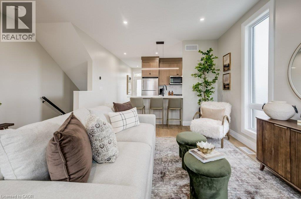 Open-concept living space featuring wood-finish flooring and recessed lighting - 210 Heritage Drive Unit# Main, Kitchener, ON - Indoor Photo Showing Living Room