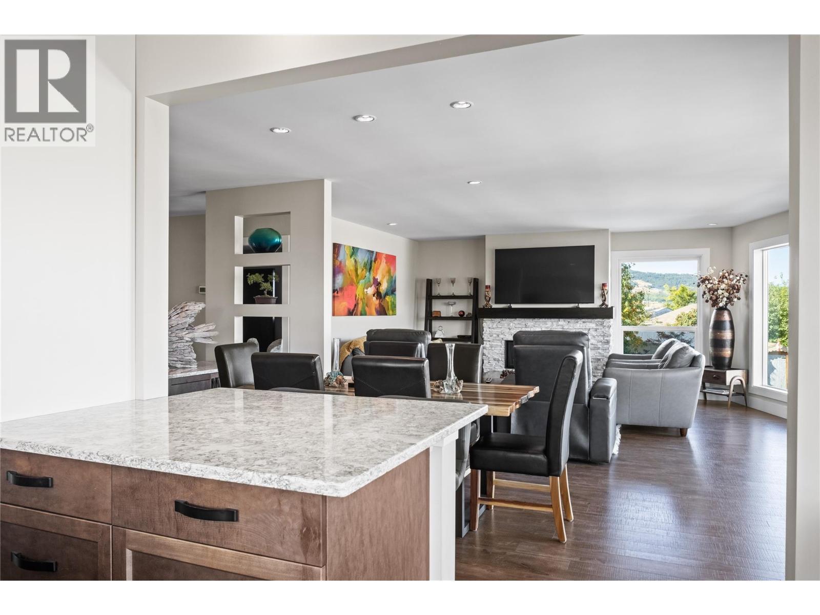 View from Kitchen through Dinnign Room to Living Room - 4119 15 Avenue, Vernon, BC - Indoor With Fireplace