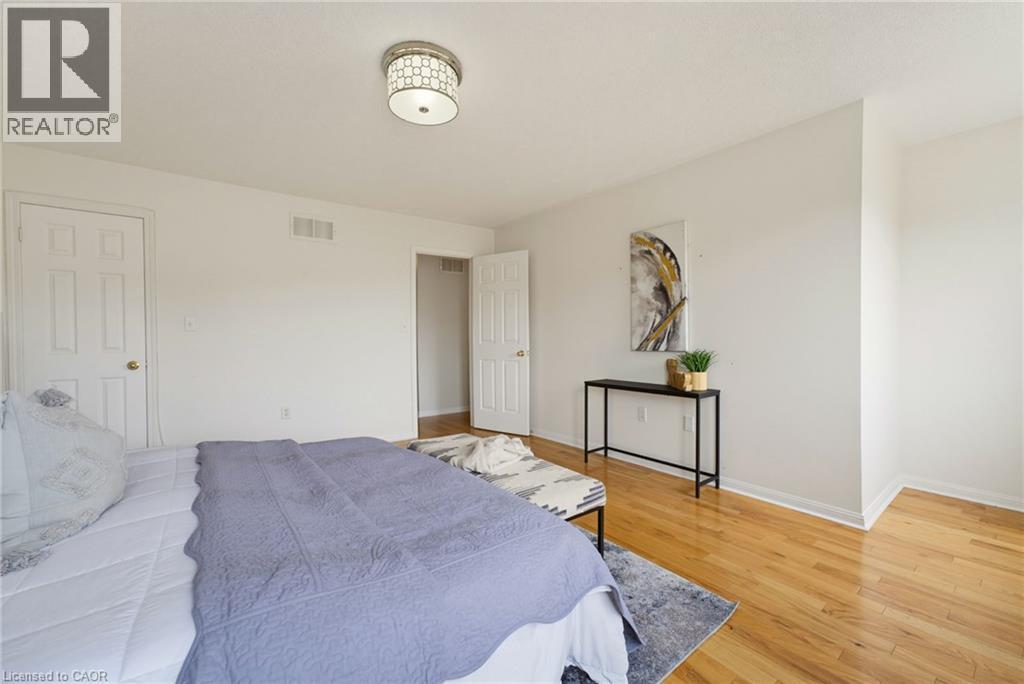 Hardwood flooring throughout, white painted walls, and a decorative flush mount ceiling light fixture - 4425 Peter Drive, Burlington, ON - Indoor Photo Showing Bedroom