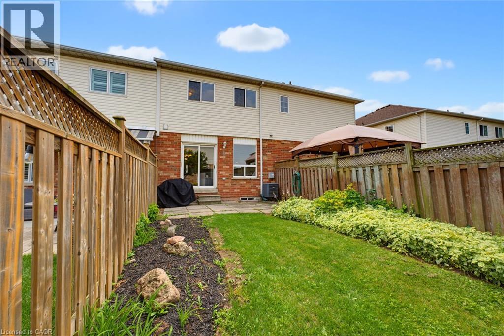 Expansive backyard featuring a manicured lawn and mature privacy fencing - 4425 Peter Drive, Burlington, ON - Outdoor With Deck Patio Veranda With Exterior