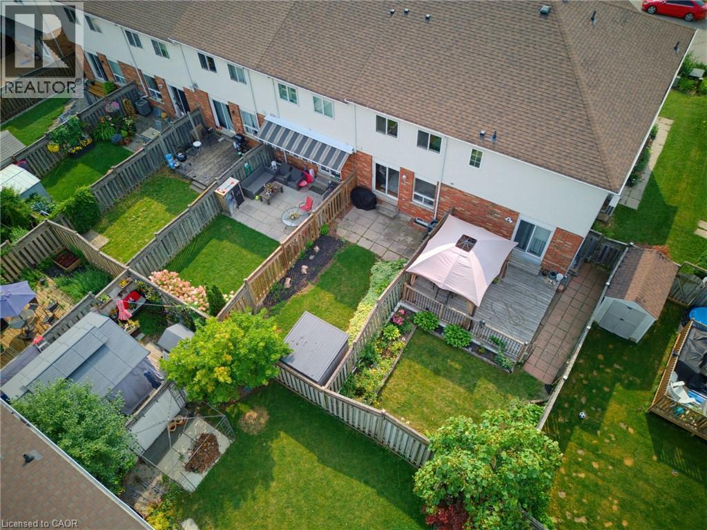 Private fenced backyard featuring a wooden deck, concrete patio, and manicured lawn - 4425 Peter Drive, Burlington, ON - Outdoor With View
