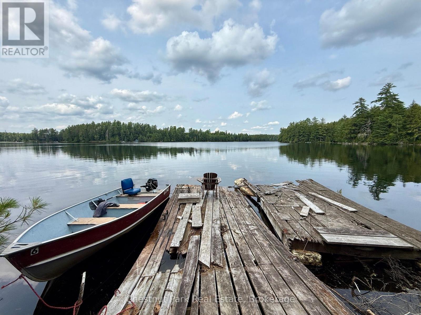Wide angle of dock & bay. This boat not included - 50 Cache Lake Apl1322, South Algonquin, ON - Outdoor With Body Of Water With Deck Patio Veranda With View
