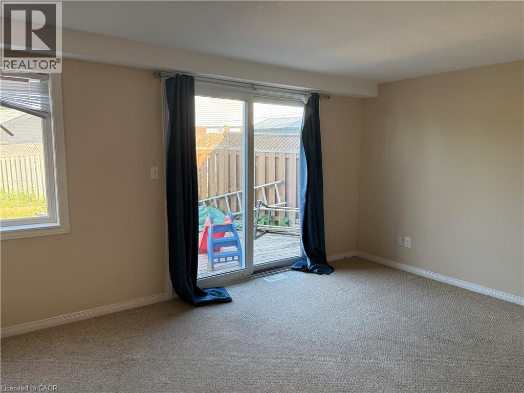 Carpeted room featuring a large sliding glass door opening to a deck - 11 Hackberry Street Unit# 1, Kitchener, ON - Indoor Photo Showing Other Room