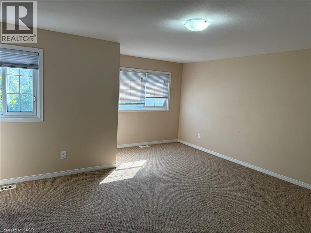 Carpeted room with neutral tone walls and white trim - 11 Hackberry Street Unit# 1, Kitchener, ON - Indoor Photo Showing Other Room