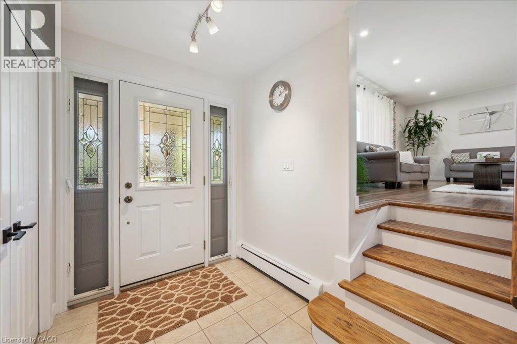 Entryway featuring a decorative glass front door with sidelights, ceramic tile flooring, and track lighting - 76 Lower Canada Crescent, Kitchener, ON - Indoor Photo Showing Other Room