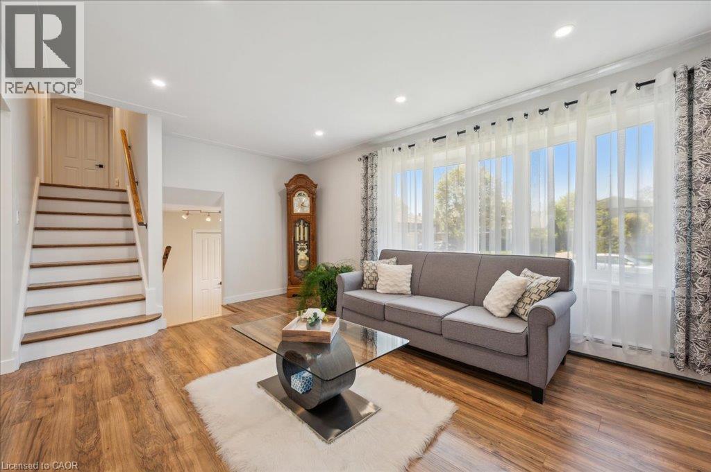 Living space featuring wood-finish flooring, recessed lighting, and a prominent staircase with wood treads and handrail - 76 Lower Canada Crescent, Kitchener, ON - Indoor Photo Showing Living Room
