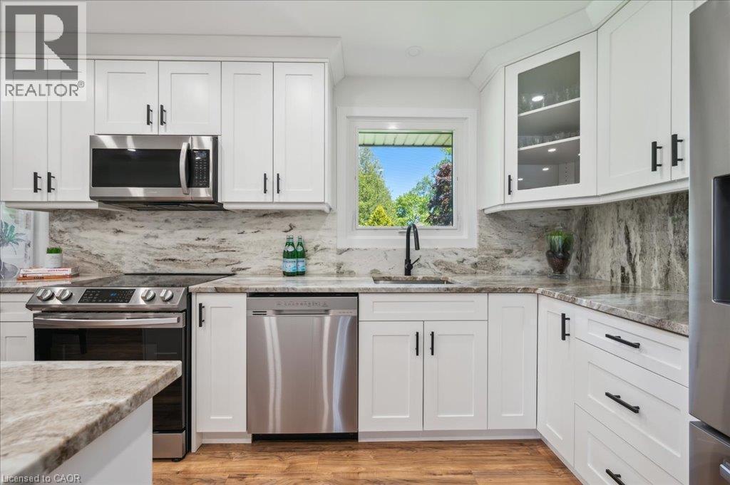 Modern kitchen with white shaker cabinetry, stainless steel appliances, and wood-finish flooring - 76 Lower Canada Crescent, Kitchener, ON - Indoor Photo Showing Kitchen With Upgraded Kitchen