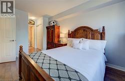 Spacious room with wood-finish flooring and light-toned walls -
