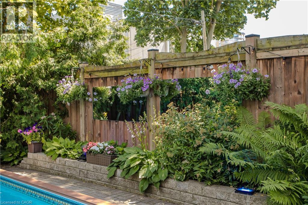 Outdoor wood fence with integrated mirrors and hanging planters - 569 Locust Street, Burlington, ON - Outdoor With In Ground Pool