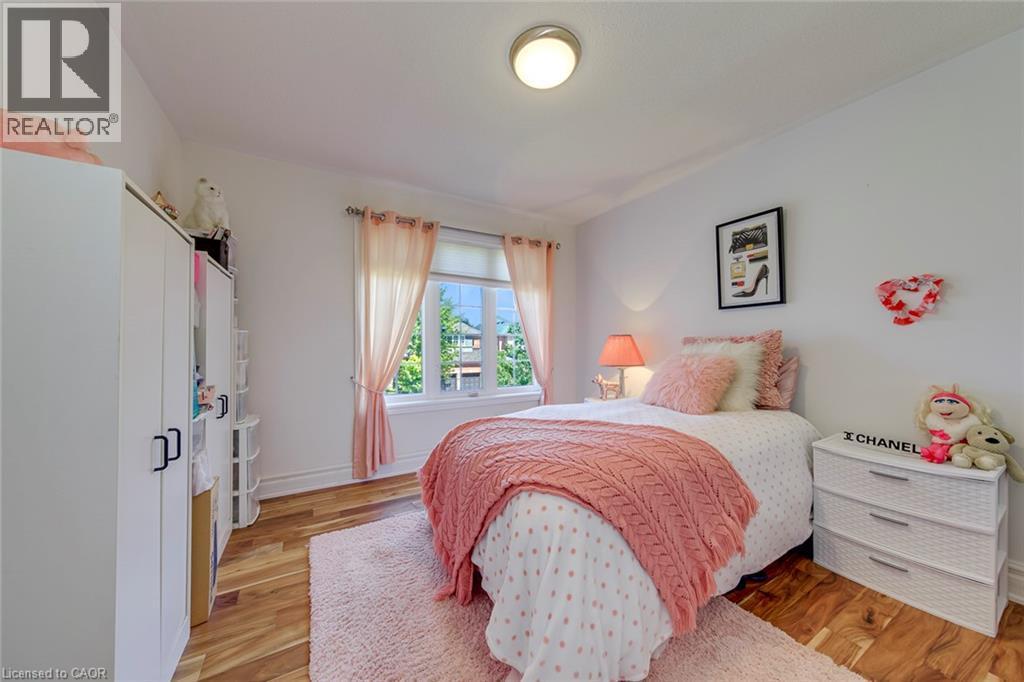 Room featuring wood-finish flooring, white painted walls, and a prominent window - 2380 Woodcrest Drive, Oakville, ON - Indoor Photo Showing Bedroom
