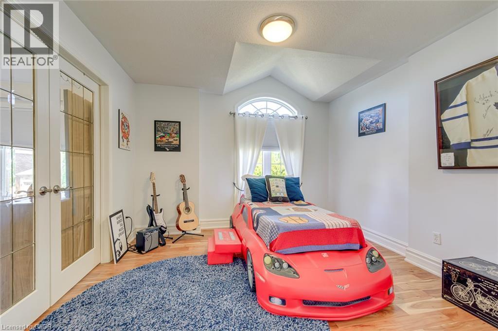 Room featuring wood-finish flooring, a vaulted ceiling, and an arched window - 2380 Woodcrest Drive, Oakville, ON - Indoor