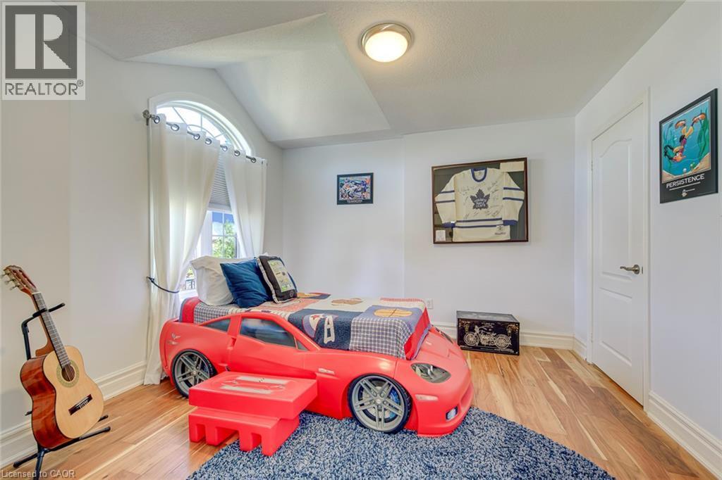 Hardwood-finish flooring featuring a window with an arched transom, substantial white trim, and a paneled interior door - 2380 Woodcrest Drive, Oakville, ON - Indoor