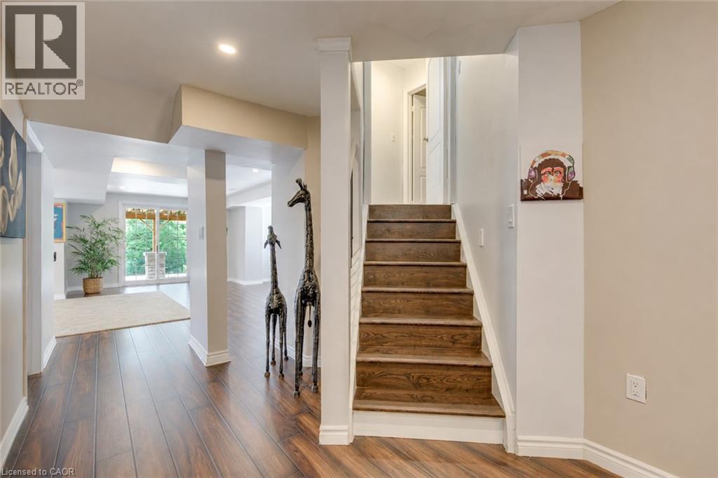Hardwood-finish flooring throughout the hallway and open-concept room - 2380 Woodcrest Drive, Oakville, ON - Indoor Photo Showing Other Room