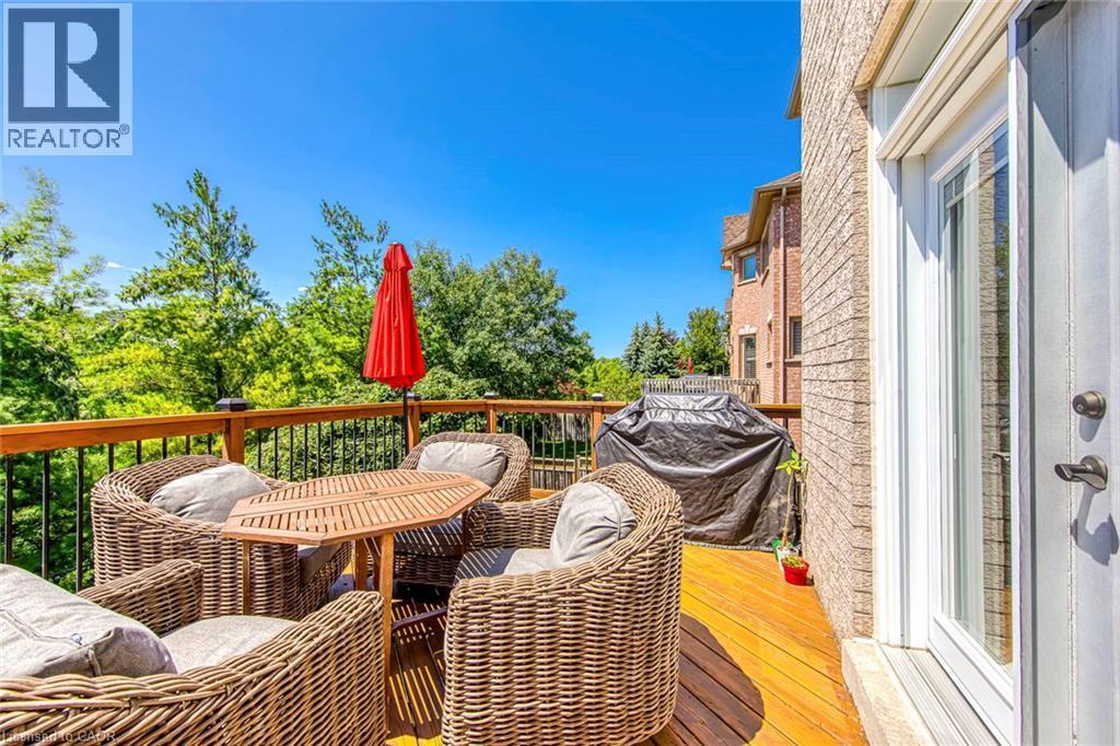 Expansive wood-finish deck with black metal balusters and a brick exterior - 2380 Woodcrest Drive, Oakville, ON - Outdoor With Exterior