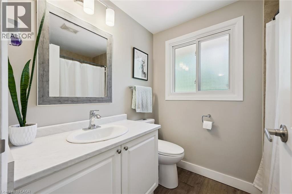 Bathroom featuring a white vanity with an integrated sink, chrome faucet, and a large framed mirror - 589 Elgin Street N, Cambridge, ON - Indoor Photo Showing Bathroom
