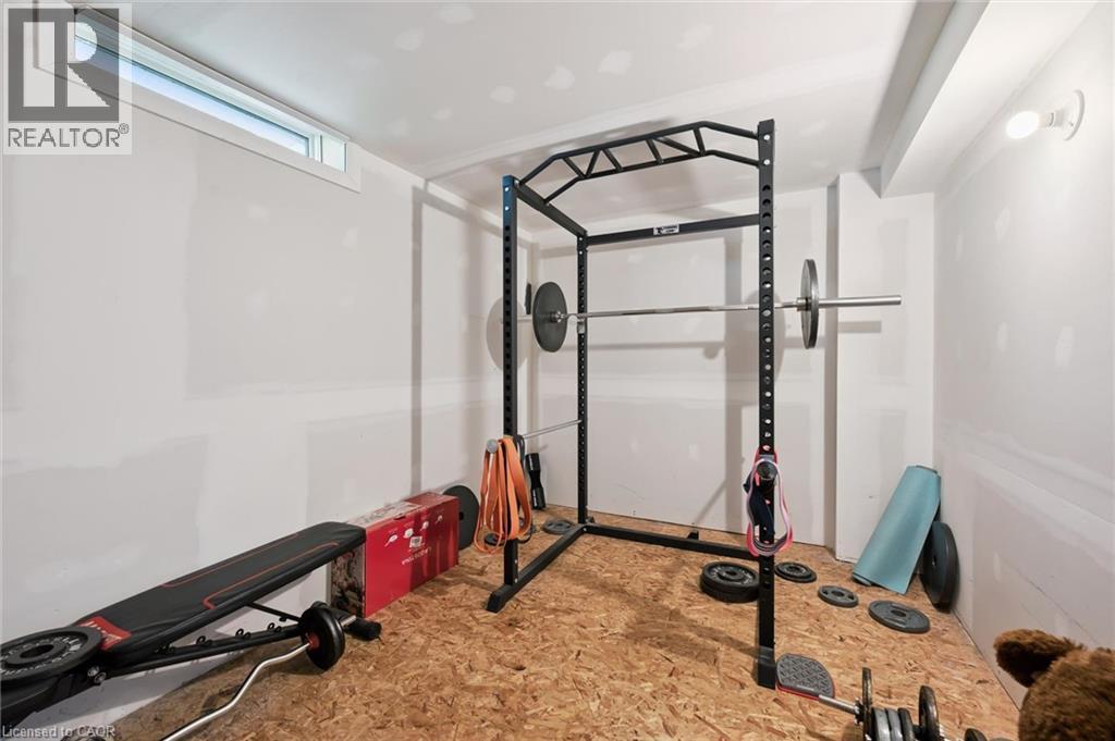 Unfinished basement space featuring a subfloor and exposed drywall, a single horizontal window, and a ceiling-mounted light fixture - 589 Elgin Street N, Cambridge, ON - Indoor Photo Showing Gym Room