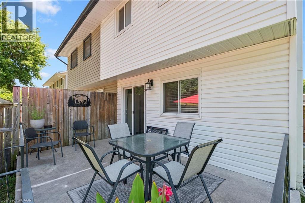 Private concrete patio with a wooden privacy fence - 589 Elgin Street N, Cambridge, ON - Outdoor With Deck Patio Veranda With Exterior