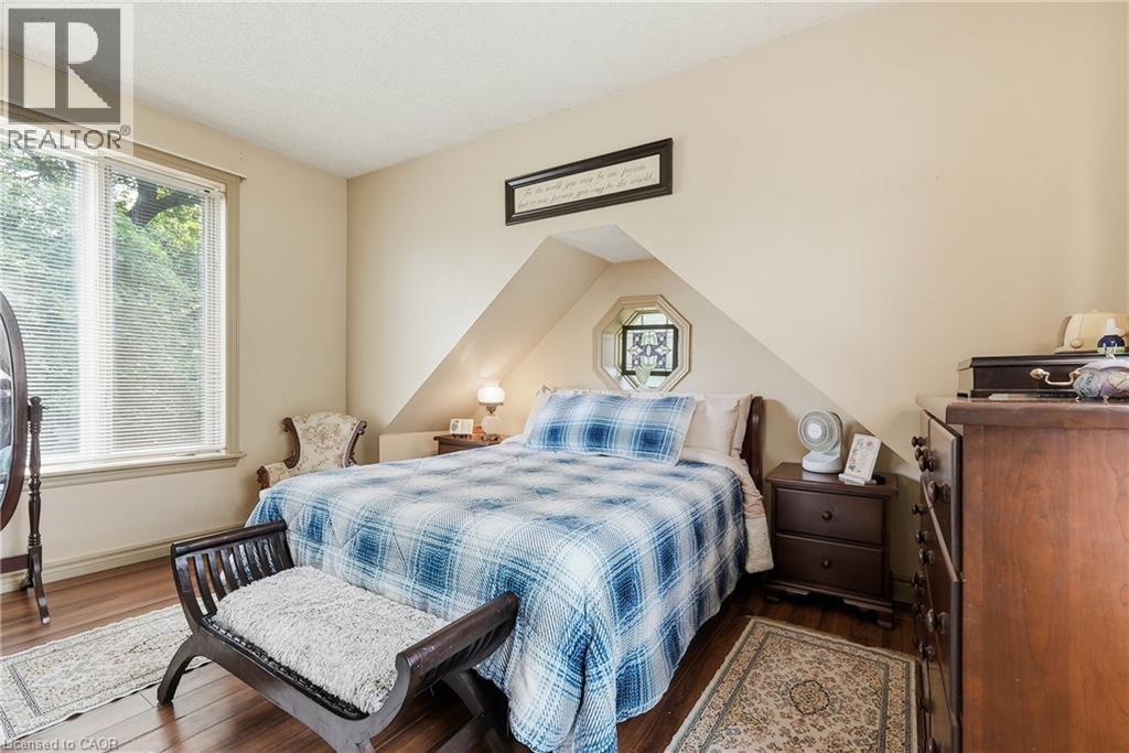 Room featuring wood-finish flooring, a double window with blinds, and an octagonal window - 153 Montrose Street N, Cambridge, ON - Indoor Photo Showing Bedroom