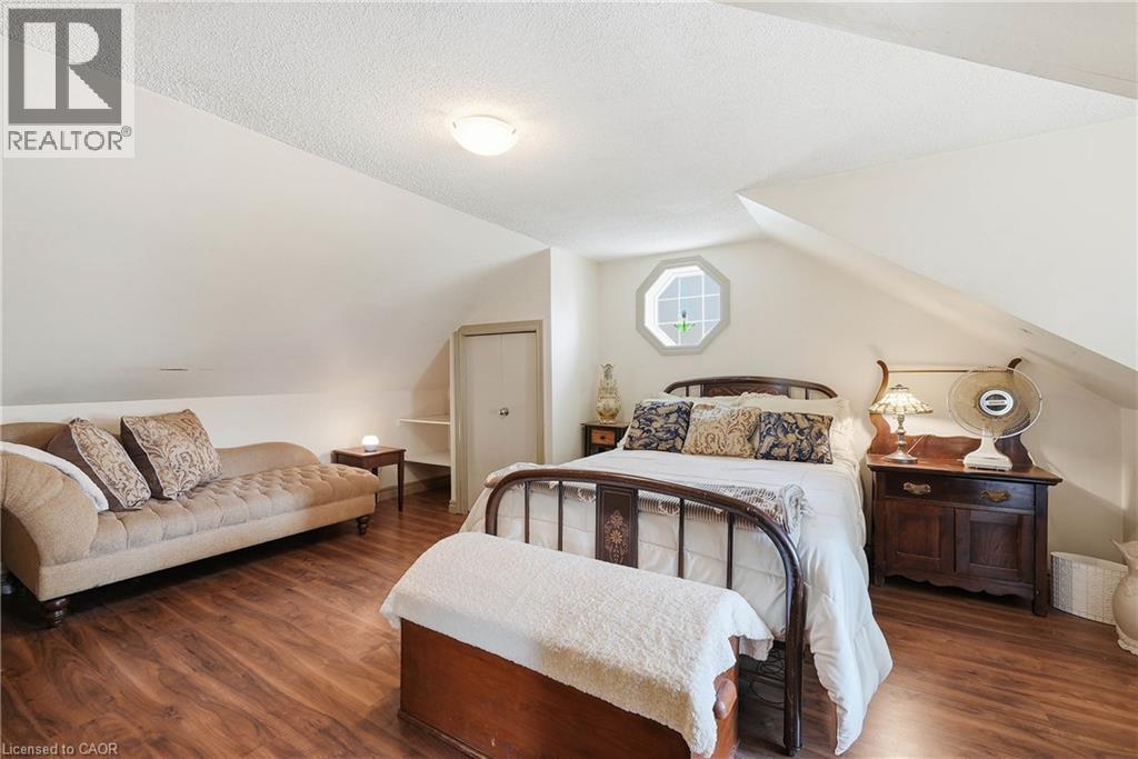 Room with sloped ceilings featuring wood-finish flooring, an octagonal window, and a built-in closet with shelving - 153 Montrose Street N, Cambridge, ON - Indoor Photo Showing Bedroom